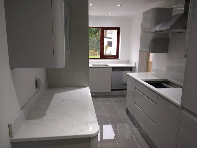 White gloss kitchen installation with marble-effect worktops